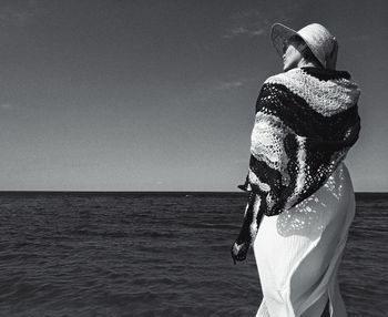 Man standing in sea against clear sky