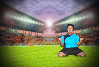 Portrait of happy young player celebrating on soccer field