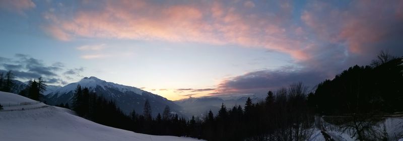 Scenic view of snowcapped mountains against sky during sunset