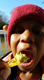 Close-up portrait of boy eating food outdoors