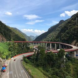 Road amidst plants and mountains against sky