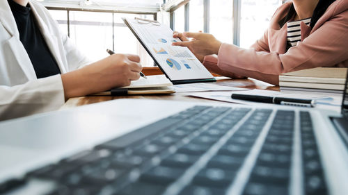 Midsection of man using laptop on table