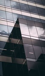 Low angle view of glass building against sky