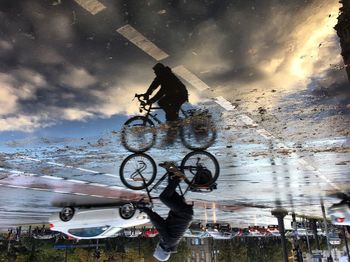 Bicycle by water against sky