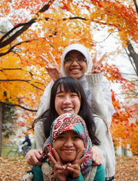 Portrait of happy friends against autumn trees at park