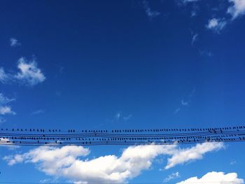 Low angle view of silhouette bridge against blue sky