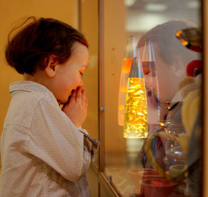 Curious boy looking at display cabinet