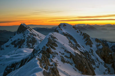 Scenic view of snowcapped mountains against sky during sunset