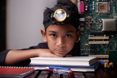 Portrait of boy with open book on table