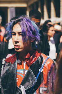 Portrait of woman with arms raised on street in city