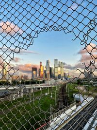 Cityscape seen through chainlink fence