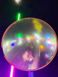 Close-up of illuminated lighting equipment against black background