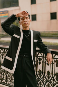 Portrait of young man standing against wall