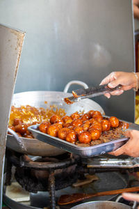 Midsection of person preparing food on barbecue grill