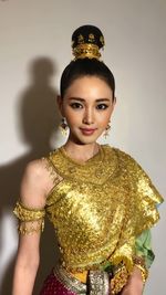 Portrait of young woman standing against white background