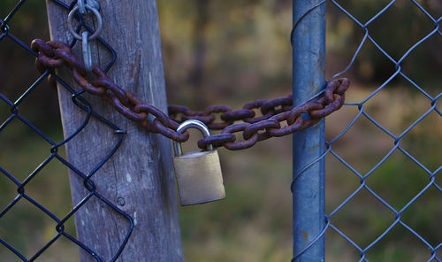 Close-up of padlock on chain on fence