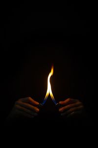 Close-up of lit candle in dark room