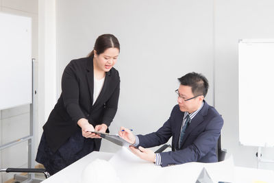Happy young couple sitting in office