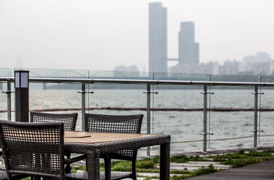 Empty table and chairs by han river