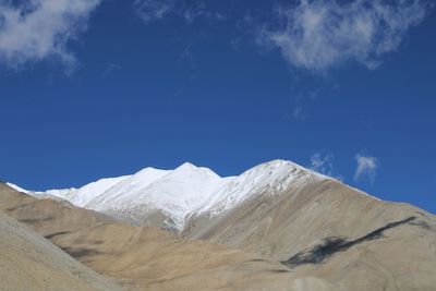 Scenic view of snowcapped mountains against blue sky