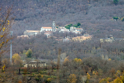 High angle view of houses on field against trees