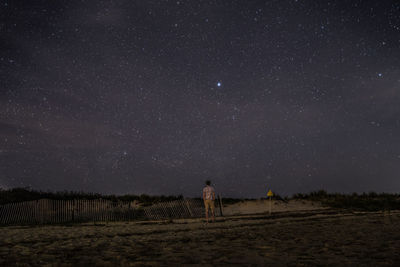 Full length of man standing on field against star in sky