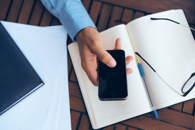 High angle view of man reading book on table