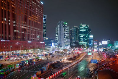 Aerial view of illuminated city street and buildings at night