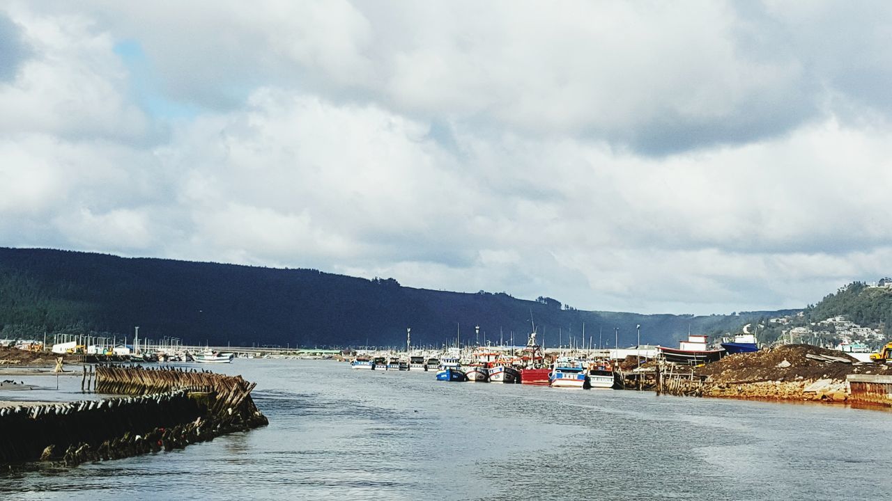 sky, mountain, cloud - sky, water, cloudy, built structure, weather, architecture, mountain range, transportation, building exterior, cloud, scenics, nature, tranquil scene, tranquility, house, beauty in nature, nautical vessel, waterfront