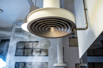 Low angle view of electric lamp hanging on ceiling in building