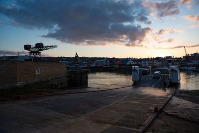 Scenic view of harbor against sky during sunset