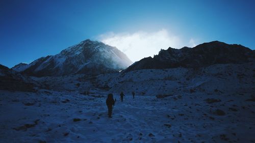 People walking on snow covered landscape