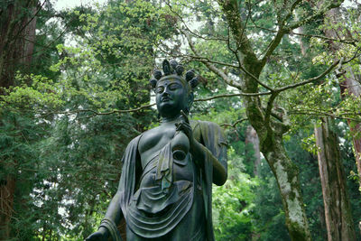 Low angle view of statue against trees