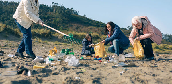Group of female volunteers picking up trash on the beach