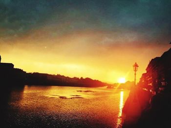 Scenic view of river against sky at sunset