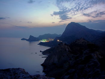 Scenic view of sea and mountains against sky