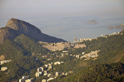 Scenic view of houses by mountain at morro dois irmaos against sea