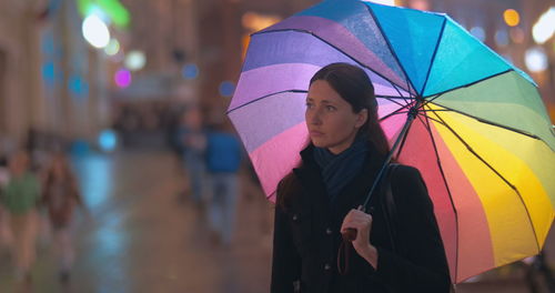 Woman with umbrella standing in rain