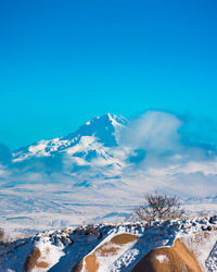 Scenic view of snowcapped mountains against blue sky