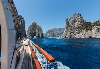 Sailboat sailing on sea against clear blue sky