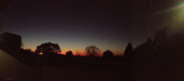 Silhouette trees against sky at sunset