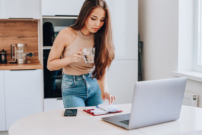 Woman using mobile phone at home