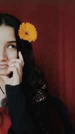 Portrait of woman with red flower in sunlight