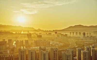 Aerial view of cityscape against sky during sunset