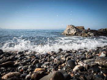 Rocks on beach against clear sky