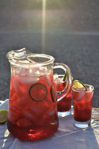 Pitcher and drink glasses of hibiscus flower iced tea in mojave desert setting