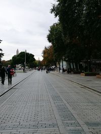 People on street in city against sky