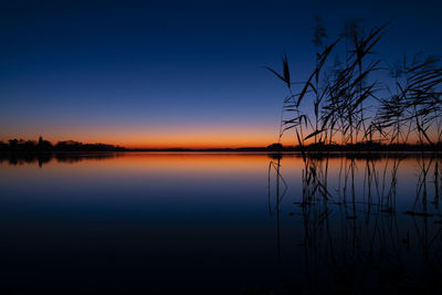 Scenic view of lake against sky at sunset