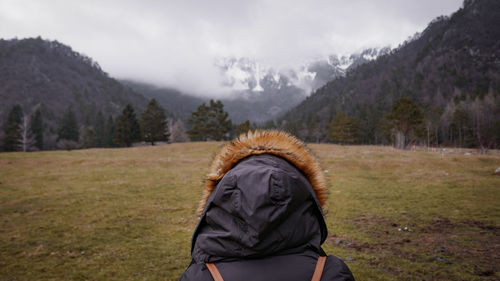 Rear view of woman wearing warm clothing on mountain during winter