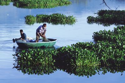 People sitting on boat in lake